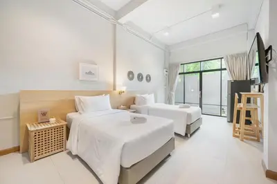 a hotel room with two beds and a television at Hotel Wizpark Ratchada in Bangkok
