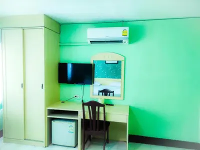 a room with a desk with a chair and a mirror at Woodlands Inn in Bangkok