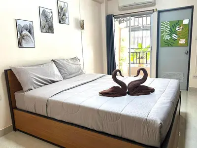 two swans sitting on a bed in a bedroom at 66 Apartment in Ban Khlong Nong Yai