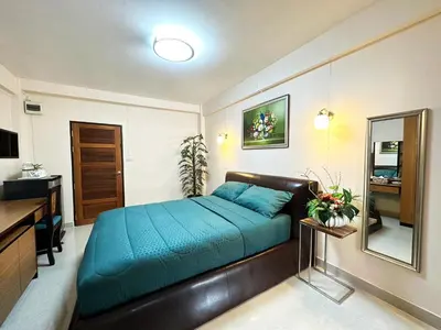 a bedroom with a blue bed and a mirror at 66 Apartment in Ban Khlong Nong Yai