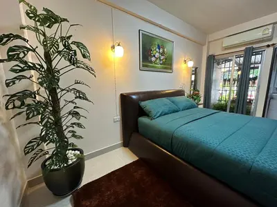 a bedroom with a bed and a potted plant at 66 Apartment in Ban Khlong Nong Yai