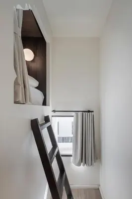 a room with a mirror and a ladder next to a window at Lilit Bang Lumphu Hotel in Bangkok