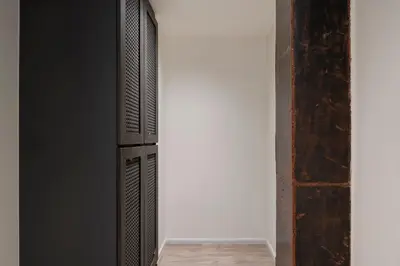 a room with an open door with a white wall at Lilit Bang Lumphu Hotel in Bangkok