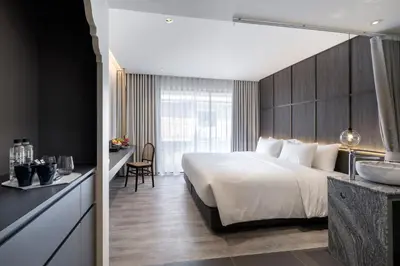 a hotel room with a large bed and a sink at Lilit Bang Lumphu Hotel in Bangkok