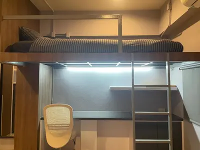 a room with a bunk bed and a chair at C2 stay Phayathai in Pom Prap