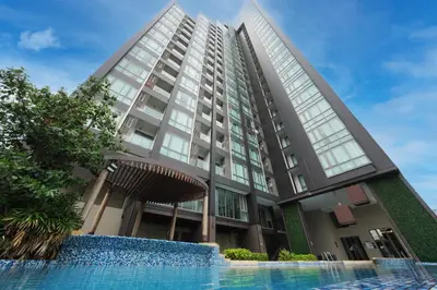 a tall building with a swimming pool in front of it at The Rich Residence Sukhumvit Nana in Bangkok