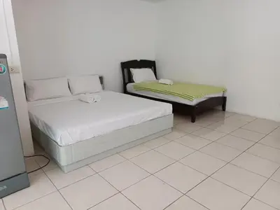 a bedroom with two beds and a couch at Grandview Condominia in Bangkok