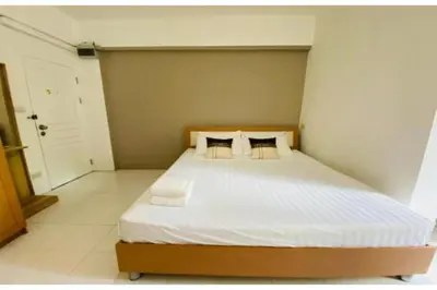 a bedroom with a bed with white sheets and pillows at Grandview Place in Bangkok