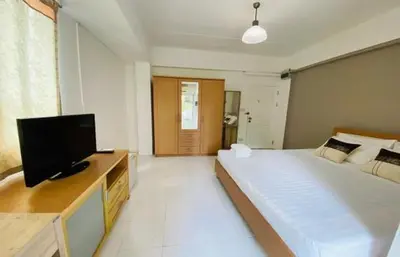 a bedroom with a large bed and a flat screen tv at Grandview Place in Bangkok