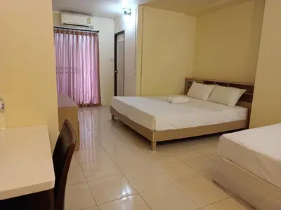 a bedroom with two beds and a table and a desk at Grandview Place in Bangkok