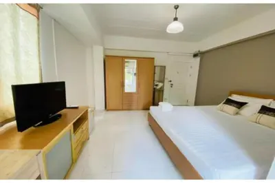 a bedroom with a large bed and a flat screen tv at Grandview Place in Bangkok