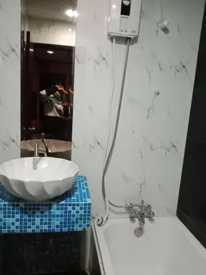 a bathroom with a white sink and a mirror at NewYork Suite Hotel in Ban Ko