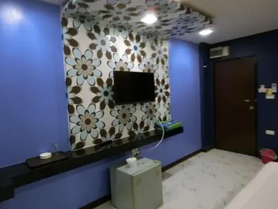 a bathroom with a tv on a blue wall at NewYork Suite Hotel in Ban Ko