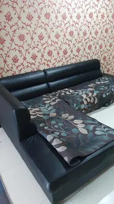 a black leather couch with a blanket on it at \u66fc\u8c37\u8d75\u5c0f\u59d0\u7684\u5e97MissZhaoHostel in Bangkok