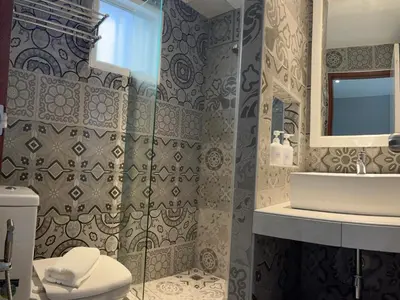 a bathroom with a shower and a toilet and a sink at Aowmana Hotel in Makkasan