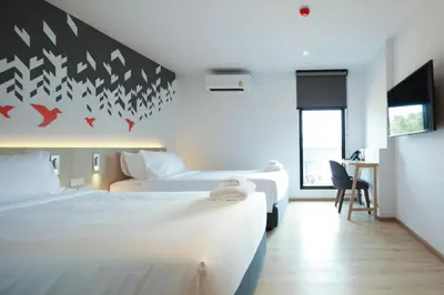 a hotel room with two beds and a desk at KOO HOTEL in Ban Bang Talat