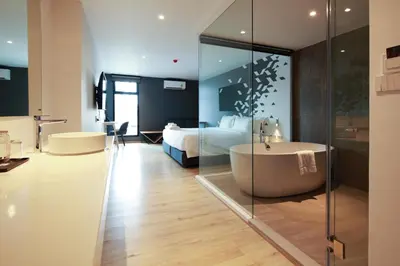 a bathroom with a tub and a bedroom with a bed at KOO HOTEL in Ban Bang Talat