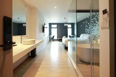 a bathroom with a tub and a bed and a bedroom at KOO HOTEL in Ban Bang Talat