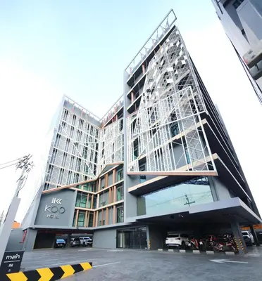 a large building with cars parked in a parking lot at KOO HOTEL in Ban Bang Talat
