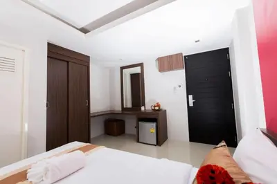 a bedroom with a white bed and a black door at Royal Asia Hotel Pratunam in Bangkok
