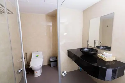 a bathroom with a black sink and a toilet at Royal Asia Hotel Pratunam in Bangkok