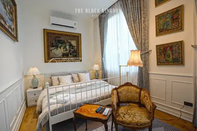 a bedroom with a bed and a chair and a table at The Black Kingdom - เดอะ แบล็ค คิงดอม in Bangkok