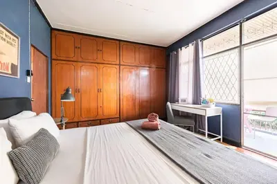 a bedroom with a large white bed and a desk at Bang Chak Homestay in Amphoe Phra Khanong