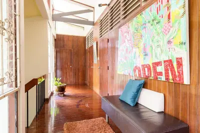 a hallway with a bench and a large painting on the wall at Bang Chak Homestay in Amphoe Phra Khanong