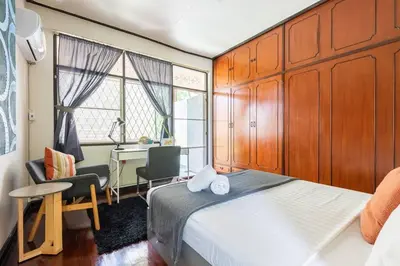 a bedroom with a bed and a desk and a table at Bang Chak Homestay in Amphoe Phra Khanong