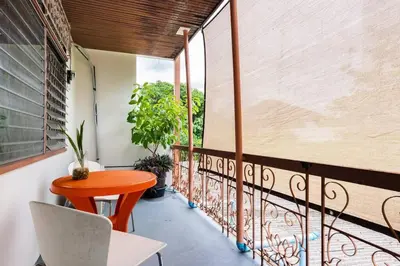 a balcony with a orange table and a chair at Bang Chak Homestay in Amphoe Phra Khanong