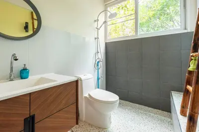 a bathroom with a toilet and a sink and a window at Bang Chak Homestay in Amphoe Phra Khanong