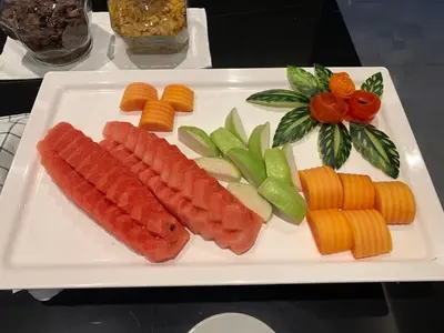 a white plate with carrots and vegetables on a table at Thana Wisut Hotel in Bangkok