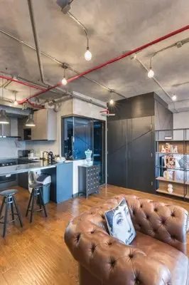 a living room with a leather couch in a kitchen at Central Bangkok Loft Style Skyline 100 sq.m. Apt in Bangkok