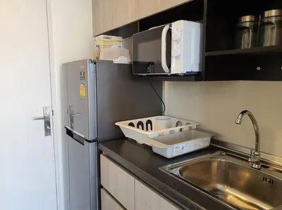 a kitchen with a sink and a refrigerator at I'M Chinatown Residence Yaowaraj Bangkok Watmungkorn MRT Station in Bangkok