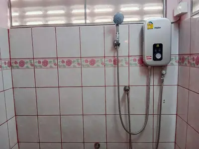 a shower in a tiled bathroom with a phone on the wall at Worakarn Apartment 1 in Bangkok