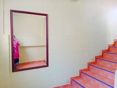 a mirror on a wall next to a staircase at Worakarn Apartment 1 in Bangkok