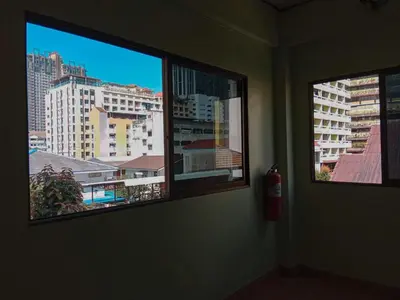 two windows in a room with a view of a city at Worakarn Apartment 2 in Bangkok