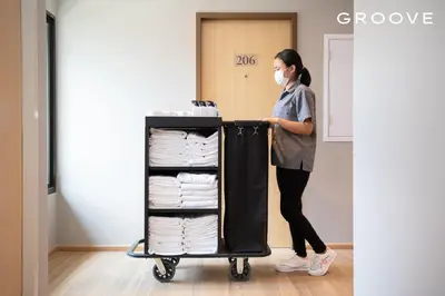 a woman is pushing a cart full of towels at GROOVE AT SIAM in Pom Prap