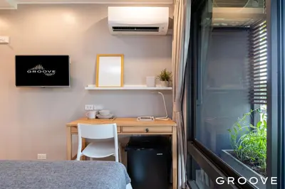 a bedroom with a desk and a bed and a window at GROOVE AT SIAM in Pom Prap