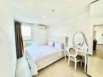a bedroom with a bed and a desk and a mirror at Town Sukhumvit 71 in Bangkok