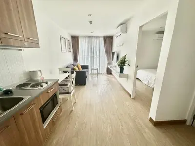a kitchen and living room with a couch and a bed at Town Sukhumvit 71 in Bangkok