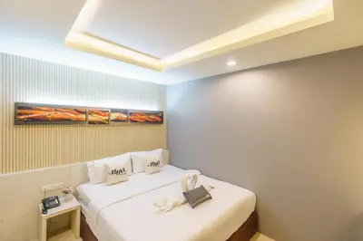 a bedroom with two beds with white sheets at De Lux Bangkok Hotel in Ban Khlong Lat Bua Khao