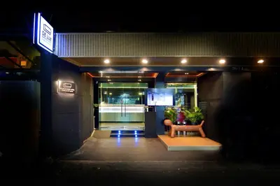 a hallway of a building with a table and plants at De Lux Bangkok Hotel in Ban Khlong Lat Bua Khao