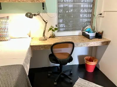 a desk in a bedroom with a chair next to a bed at OnNut Pool Homestay in Amphoe Phra Khanong