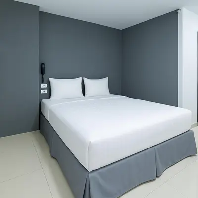 a large white bed in a blue room at Siam Rama9 Hotel in Amphoe Phra Khanong