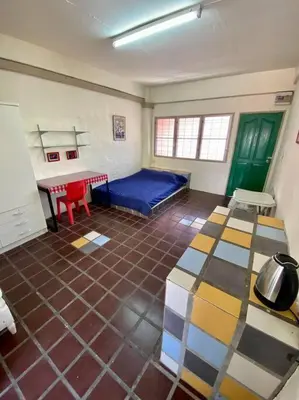 a room with a bed and a table and chairs at Ratanawong Place 520 in Bangkok