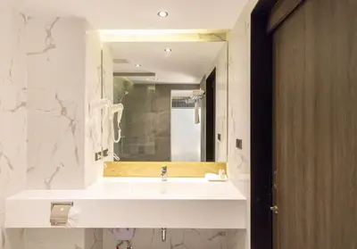 a bathroom with a white sink and a mirror at Pure Eleven Hotel Bangkok in Bangkok