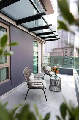 a balcony with two chairs and a table with flowers at Pure Eleven Hotel Bangkok in Bangkok