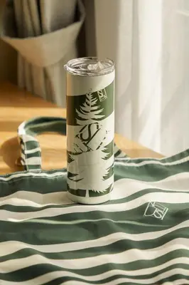 a green and white cup sitting on top of a table at Hotel Sapin in Pom Prap