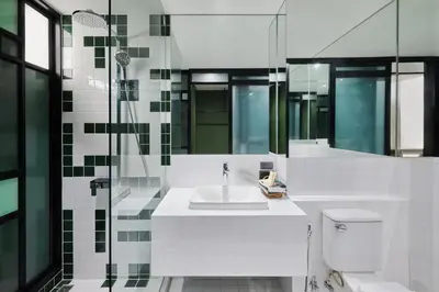 a white bathroom with a sink and a toilet at Hotel Sapin in Pom Prap